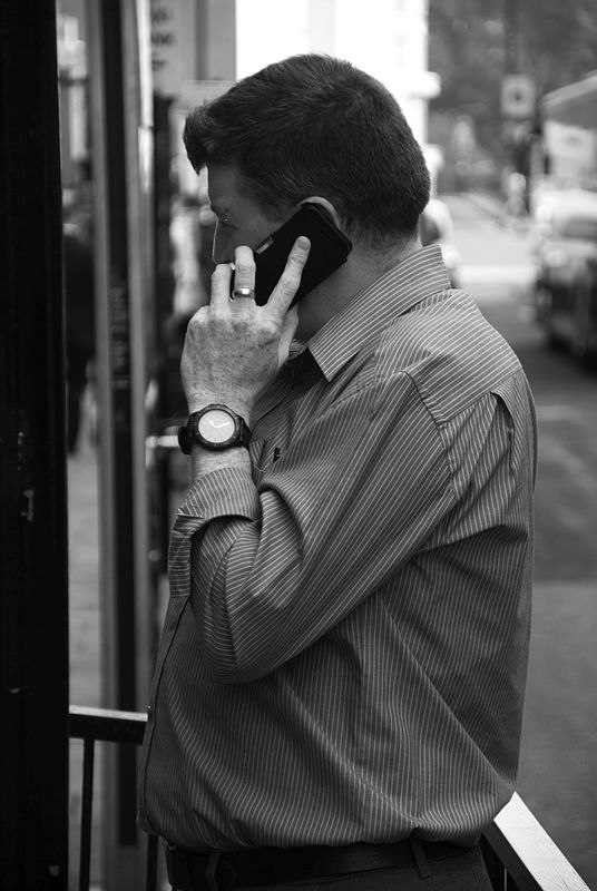 Un uomo al telefono in strada, in bianco e nero